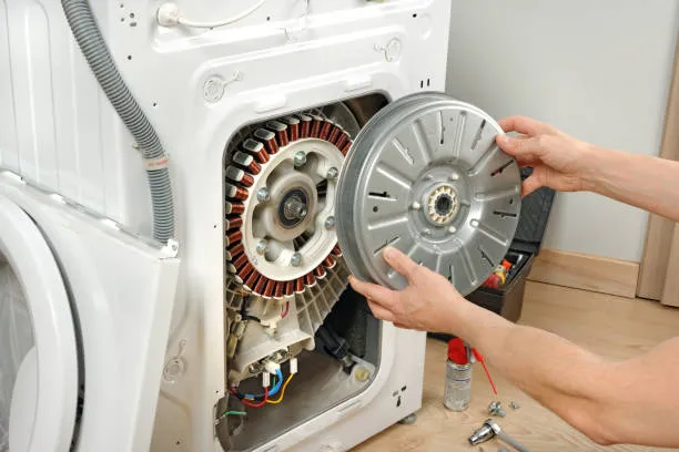 A professional 24x7 Service technician inspecting a direct drive motor for expert washing machine repair Ajman.