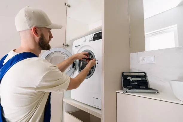 Close-up of a technician cleaning a heavily clogged lint filter to ensure safe and efficient dryer repair dubai for a client.