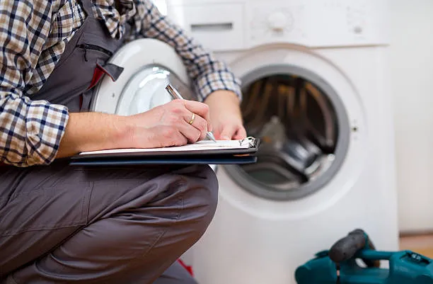 Technician inspecting a washing machine.