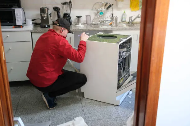 A professional specialist performing a diagnostic check on a built-in dishwasher for a high-quality dubai dishwasher repair service call.
